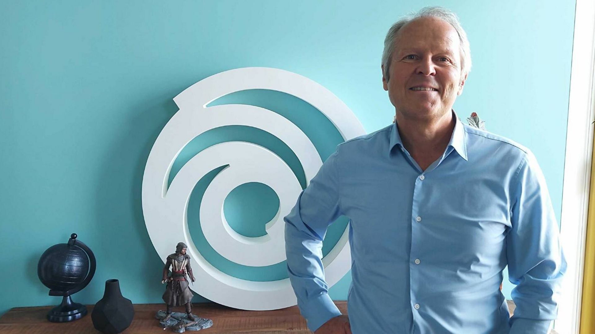 Yves Guillemot smiling next to the Ubisoft logo. He and his family currently do not want to sell Ubisoft, but Tencent’s cash injection came at very agreeable terms.